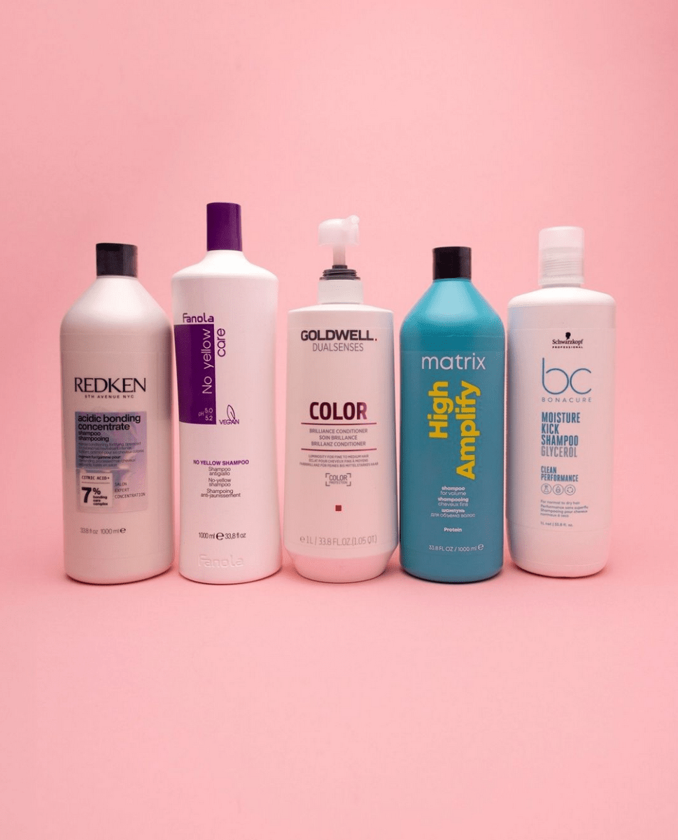 1000ml van Redken fanola goldwell matrix en schwarzkopf op een rij met roze achtergrond